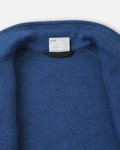 Inside collar view of the twilight blue Reima Liukuen kids' fleece jacket, showcasing the soft brushed interior lining for winter layering and a writable name tag.