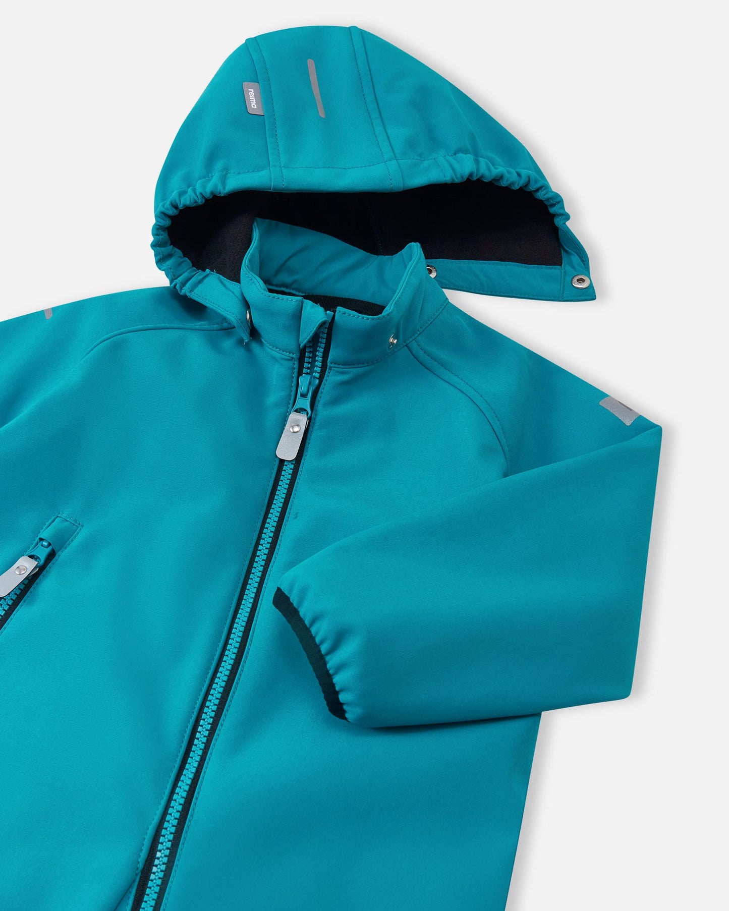 Close-up of the detachable hood and stand-up collar on the aquatic blue Reima Mjosa kids' softshell suit, showcasing the weather-resistant fabric and soft inner lining.