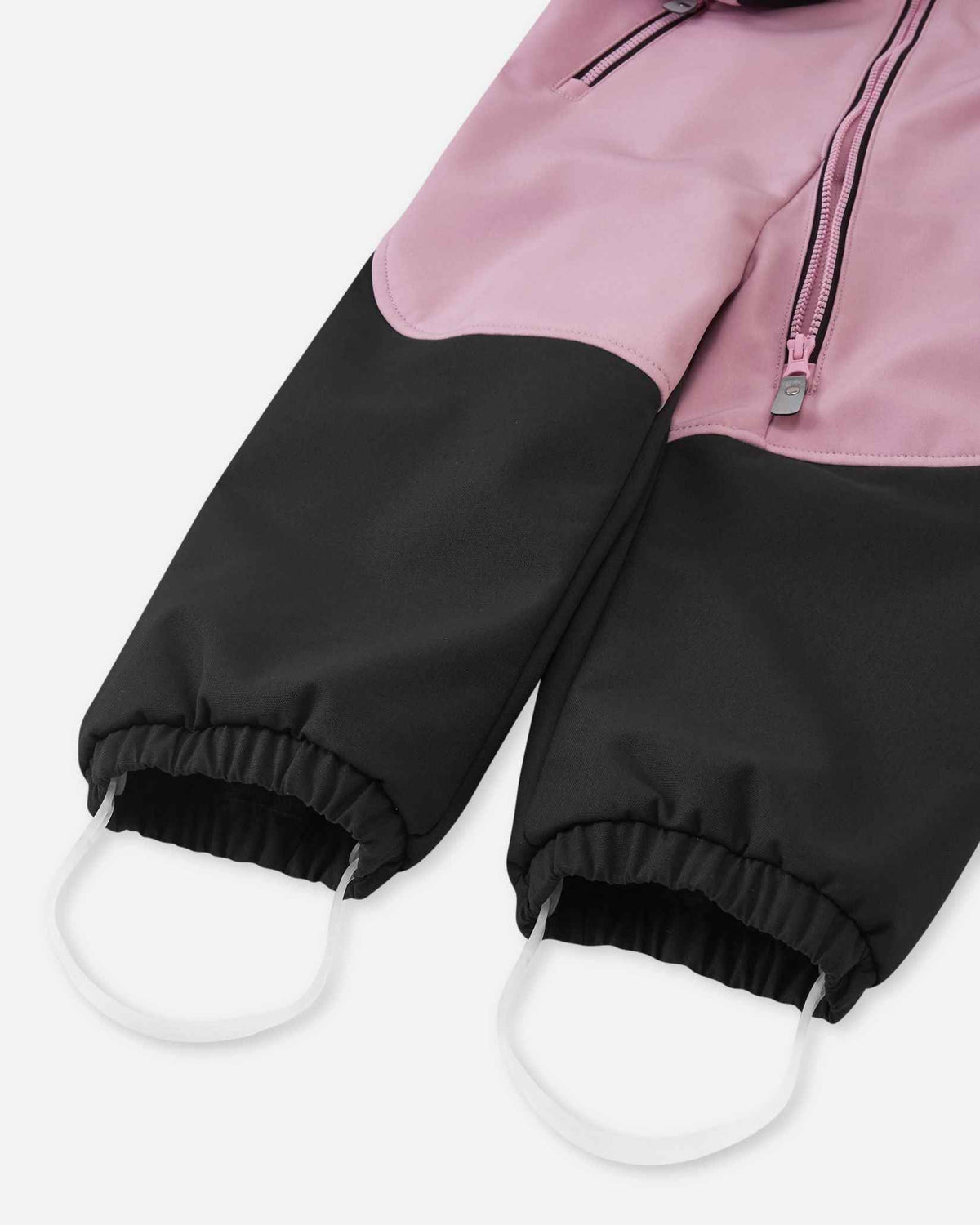 Detailed close-up of the elastic leg cuffs and durable silicone foot loops on the grey pink Reima Mjosa kids' softshell suit, designed to keep pant legs securely over boots.