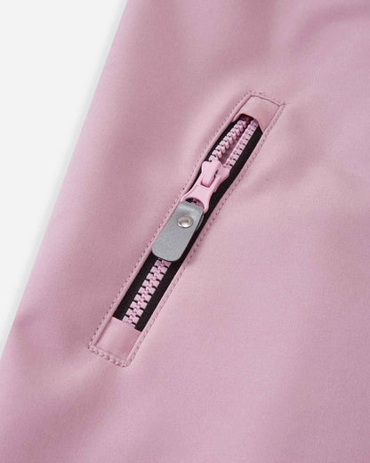 Detail view of the secure zippered pocket on the grey pink Reima Mjosa kids' softshell coverall, featuring a pink pull tab and water-resistant trimming.