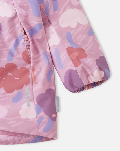 Detail shot of the Reima Muurame jacket showing a smooth zippered side pocket, a safety reflective strip, an elastic sleeve cuff to block wind, and the Reimatec waterproof technology tag.