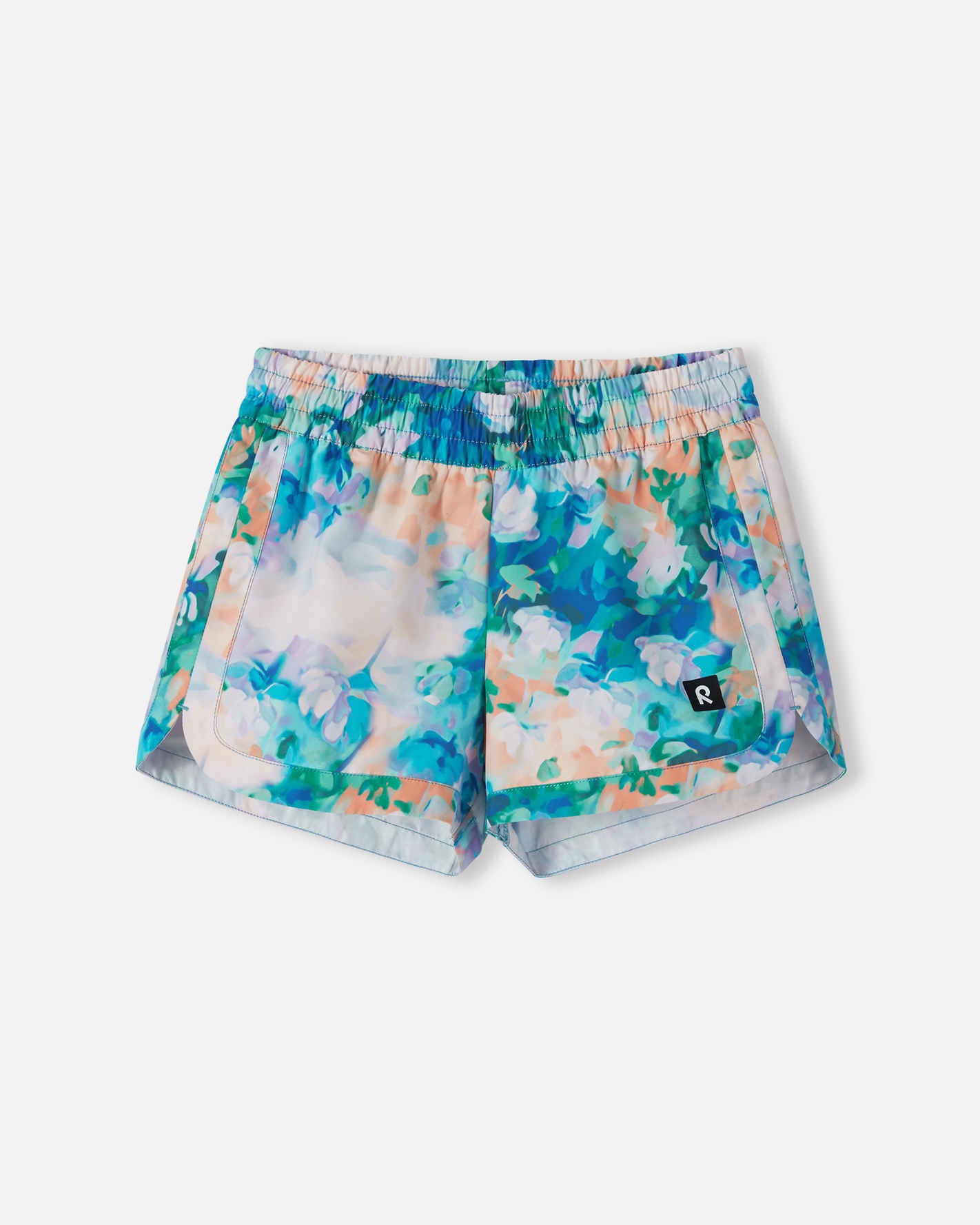 Front view of the Reima Nauru girls' UPF 50+ sunproof swim shorts, featuring a vibrant fresh blue and pastel watercolor floral print, designed with curved hems for comfortable summer mobility.