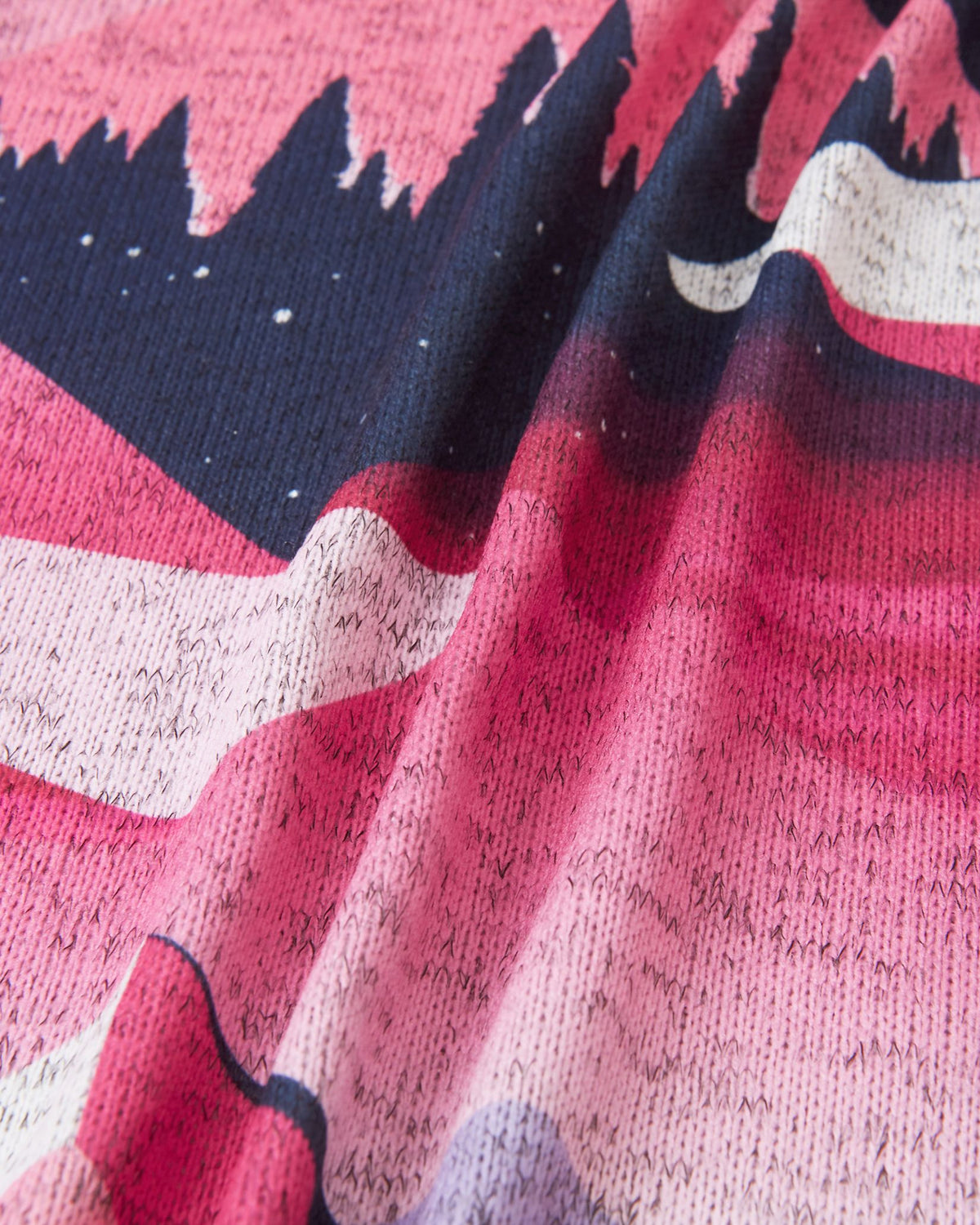 Macro close-up of the soft, thermal fleece knit fabric on the Reima Niksini kids' soft coral jacket, demonstrating its breathable and moisture-wicking properties.