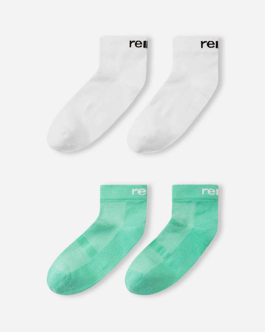 Close-up detail of the Reima Nilkat kids' fresh mint green ankle sock, highlighting the ventilated mesh paneling on the instep for moisture control and the white Reima logo on the ribbed ankle band.