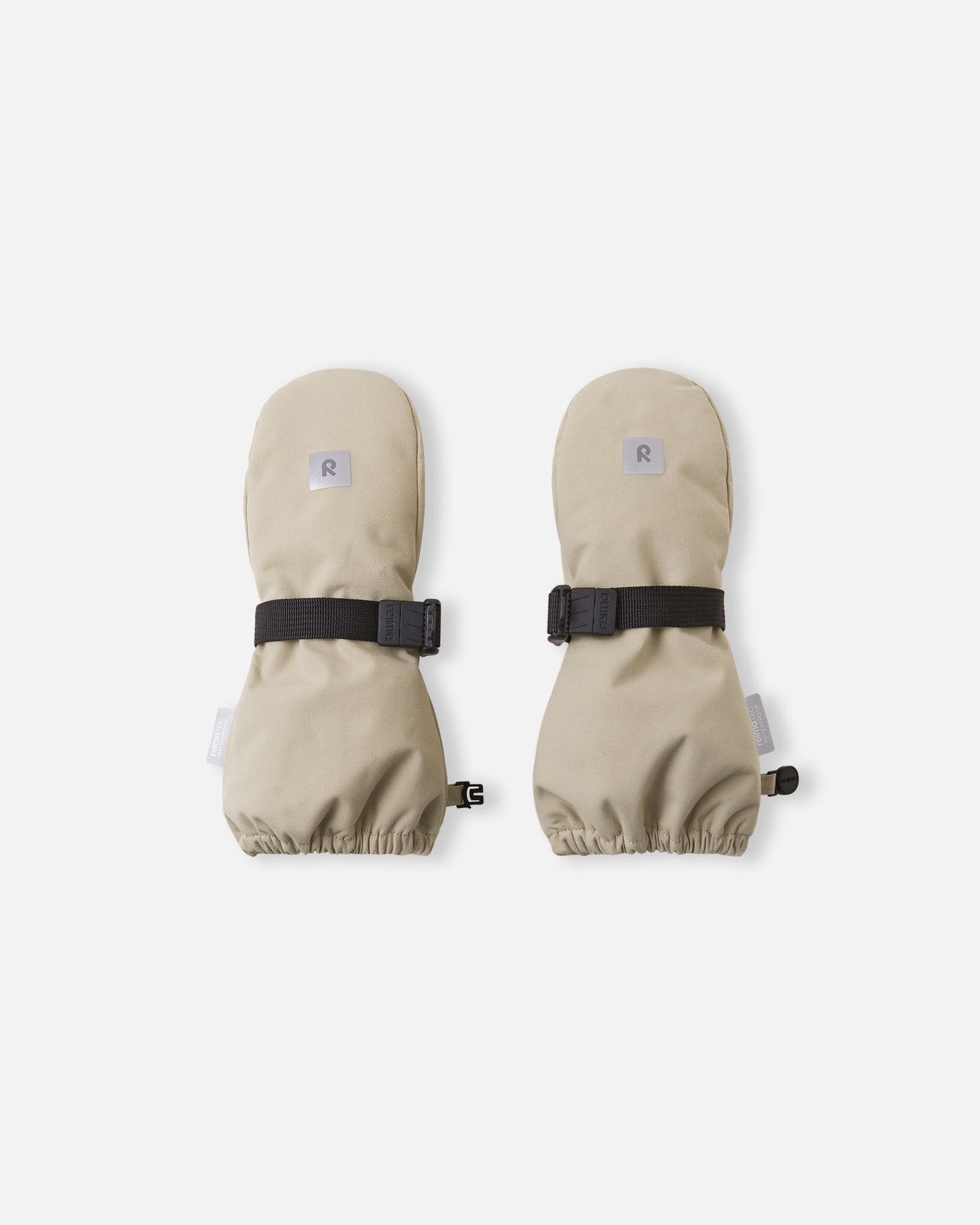 Top view of the earthy beige Reima Ote kids' winter mittens, featuring a reflective safety logo, a durable waterproof outer shell, and an adjustable black velcro wrist strap to keep out snow.