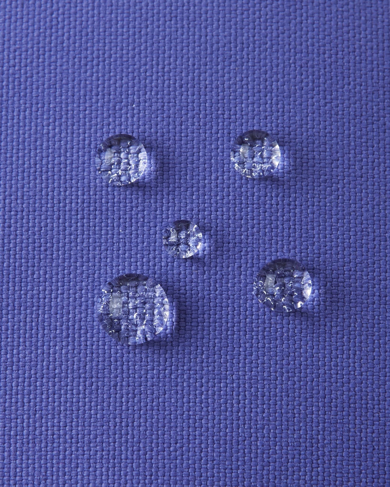 Macro close-up of water droplets beading tightly on the breezy violet Reimatec waterproof fabric of the Reima Ote kids' winter mittens, highlighting exceptional snow and moisture resistance.