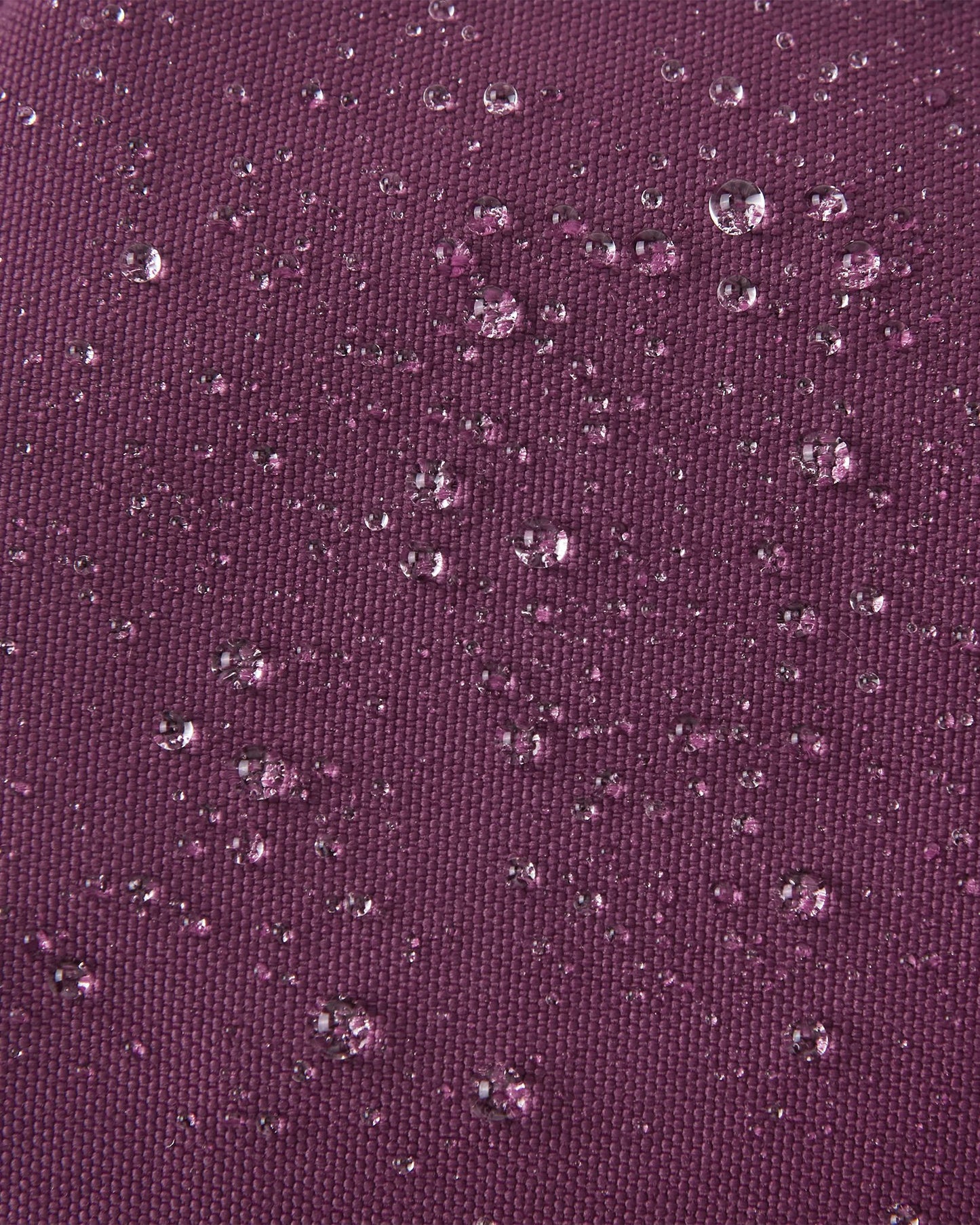 Macro close-up showing water perfectly beading off the deep purple waterproof Reimatec exterior of the Reima Ote kids' winter mittens, highlighting their advanced rain and snow resistance.