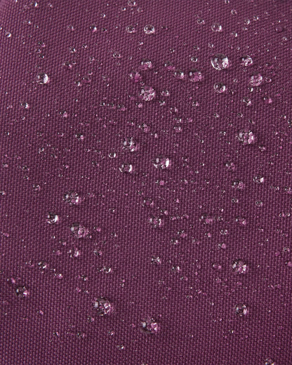 Macro close-up showing water perfectly beading off the deep purple waterproof Reimatec exterior of the Reima Ote kids' winter mittens, highlighting their advanced rain and snow resistance.