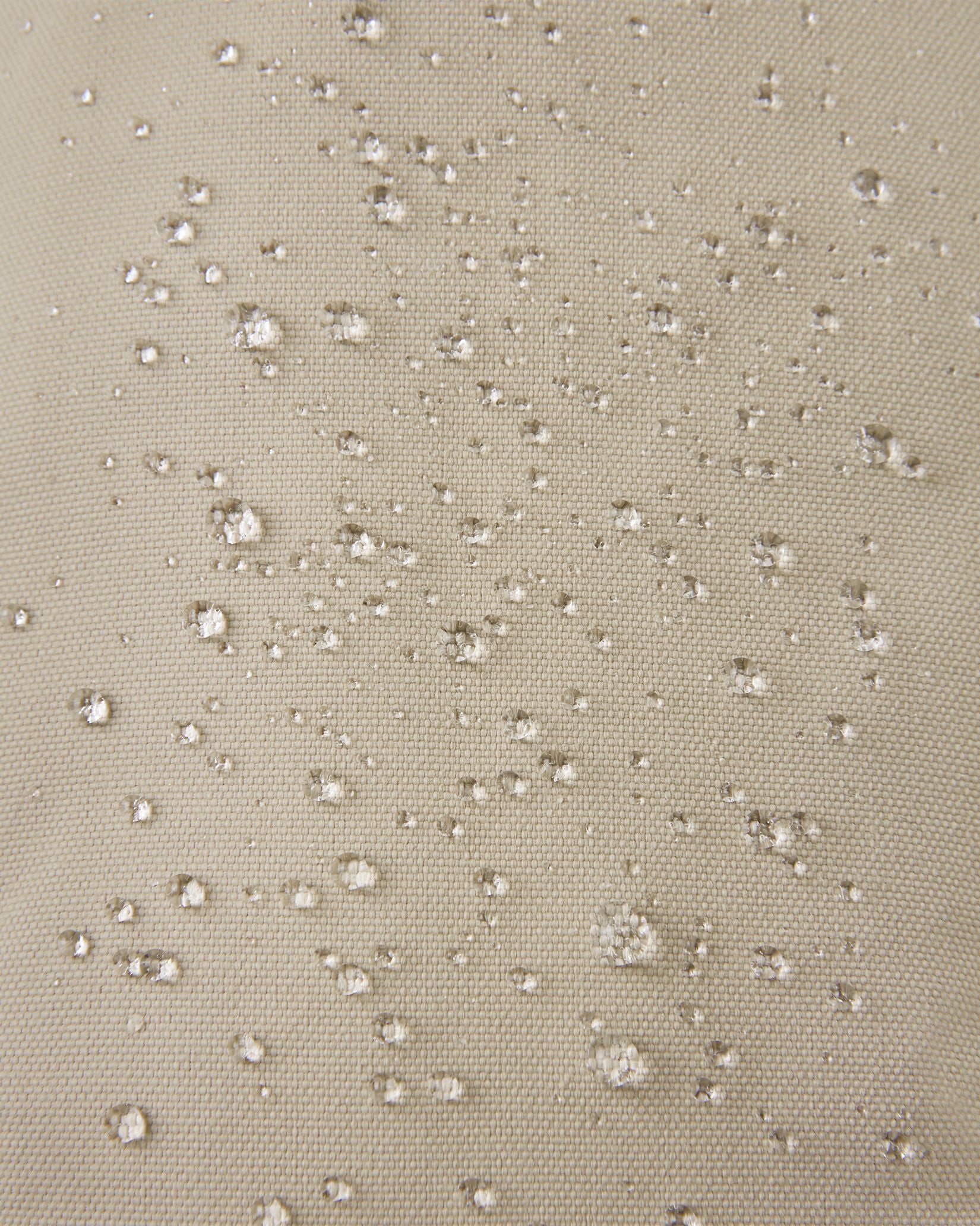 Macro close-up showing water perfectly beading off the earthy beige waterproof Reimatec exterior of the Reima Ote kids' winter mittens, demonstrating advanced rain and snow resistance.