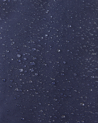 Macro close-up showing water perfectly beading off the navy blue waterproof Reimatec exterior of the Reima Ote kids' winter mittens, highlighting their advanced rain and snow resistance.