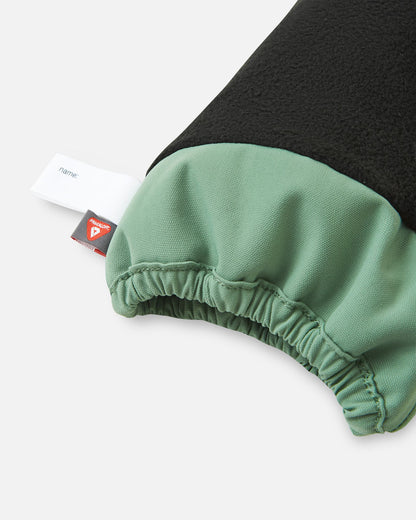 Inside cuff view of the green clay Reima Ote kids' winter mittens, highlighting the warm fleece lining, a customizable name tag, and the premium PrimaLoft insulation tag for superior cold-weather warmth.