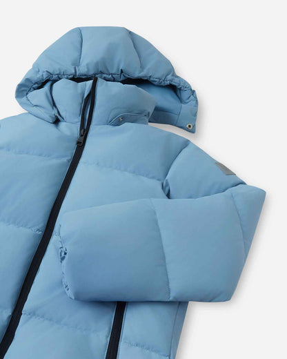 Close-up angled view of the upper torso, stand collar, and snap-off insulated hood on the cloudy blue Reima Paimio kids' winter down jacket, designed for versatile cold-weather protection.