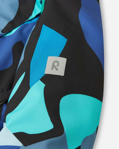 The reflective Reima R logo sits on the sleeve of the blue abstract camo coat.
