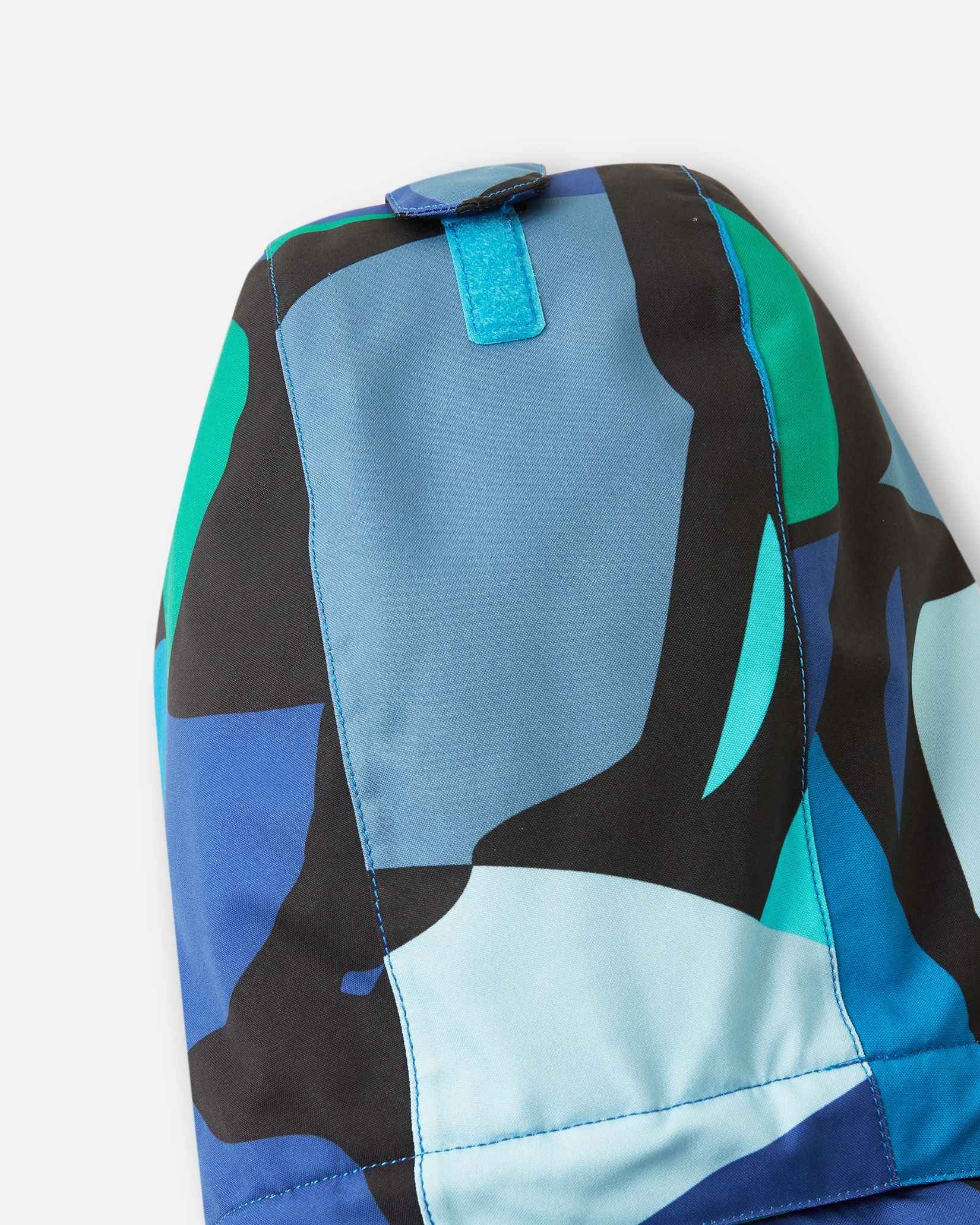Detail view of the sleeve on the Reima Palsi Ski Jacket in the Aquatic colorway, showing the bright geometric design.