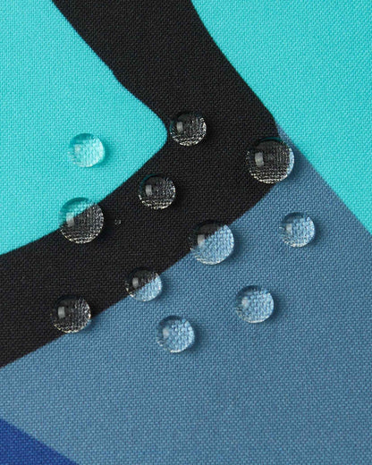Close-up of water droplets beading on the teal and black fabric of the Aquatic Reima Palsi Ski Jacket, demonstrating its water resistance.