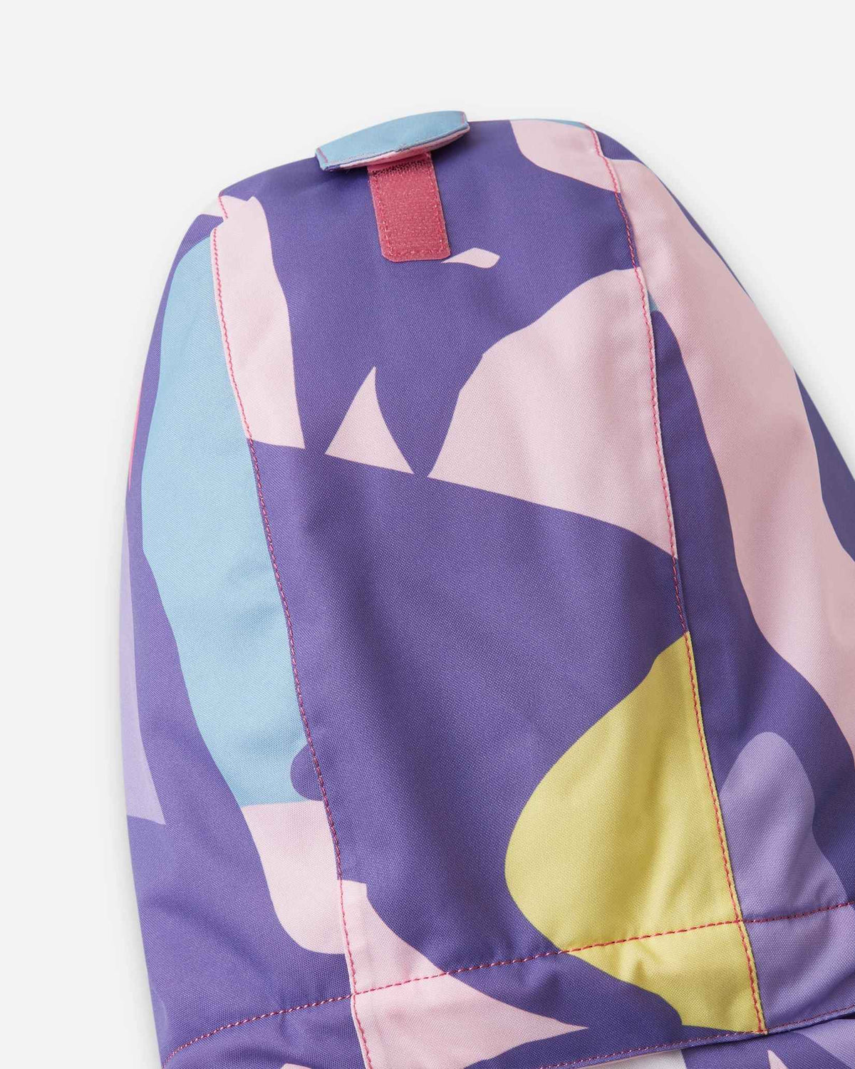 The back of the blooming lilac kids coat is folded flat to display the pink and purple shapes.