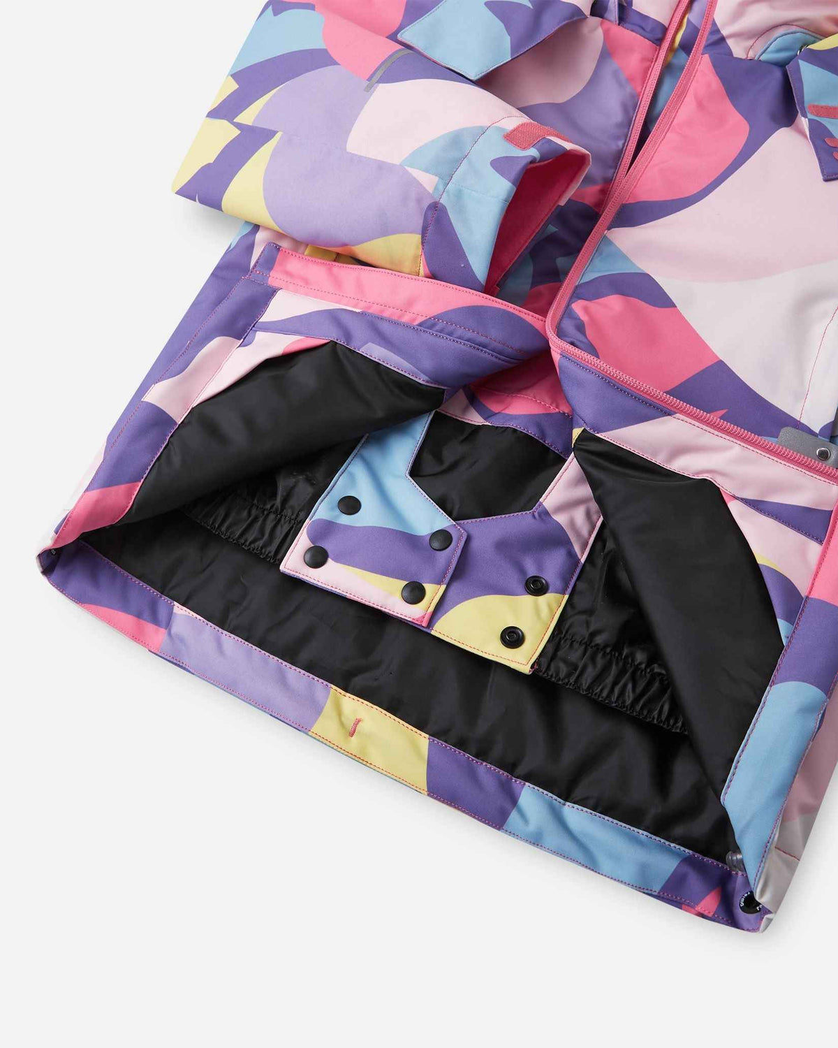 A close-up view of the inner black snow skirt and snap button closures on the Blooming Lilac Reima Palsi ski jacket.