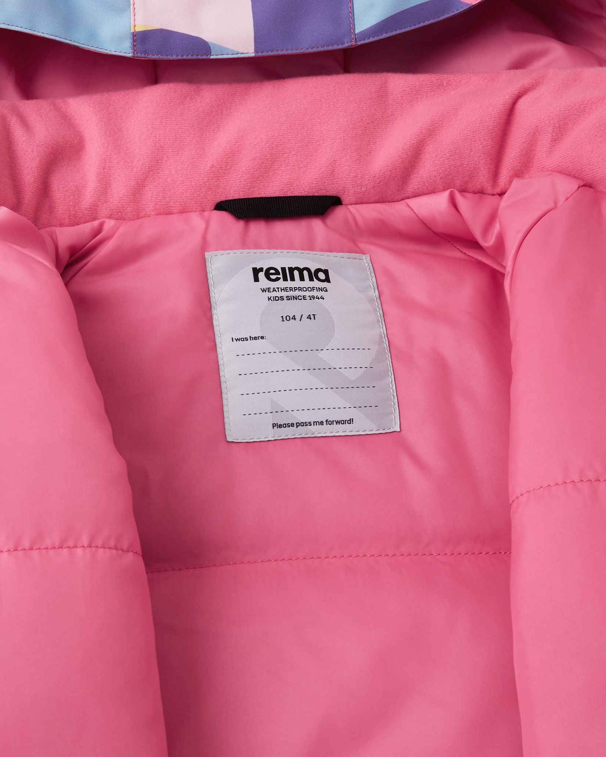 A close-up view of the inner neck label and bright pink lining on the Blooming Lilac Reima Palsi ski jacket.