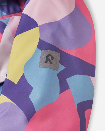 A silver Reima patch rests against the purple and yellow geometric pattern of the ski sleeve.