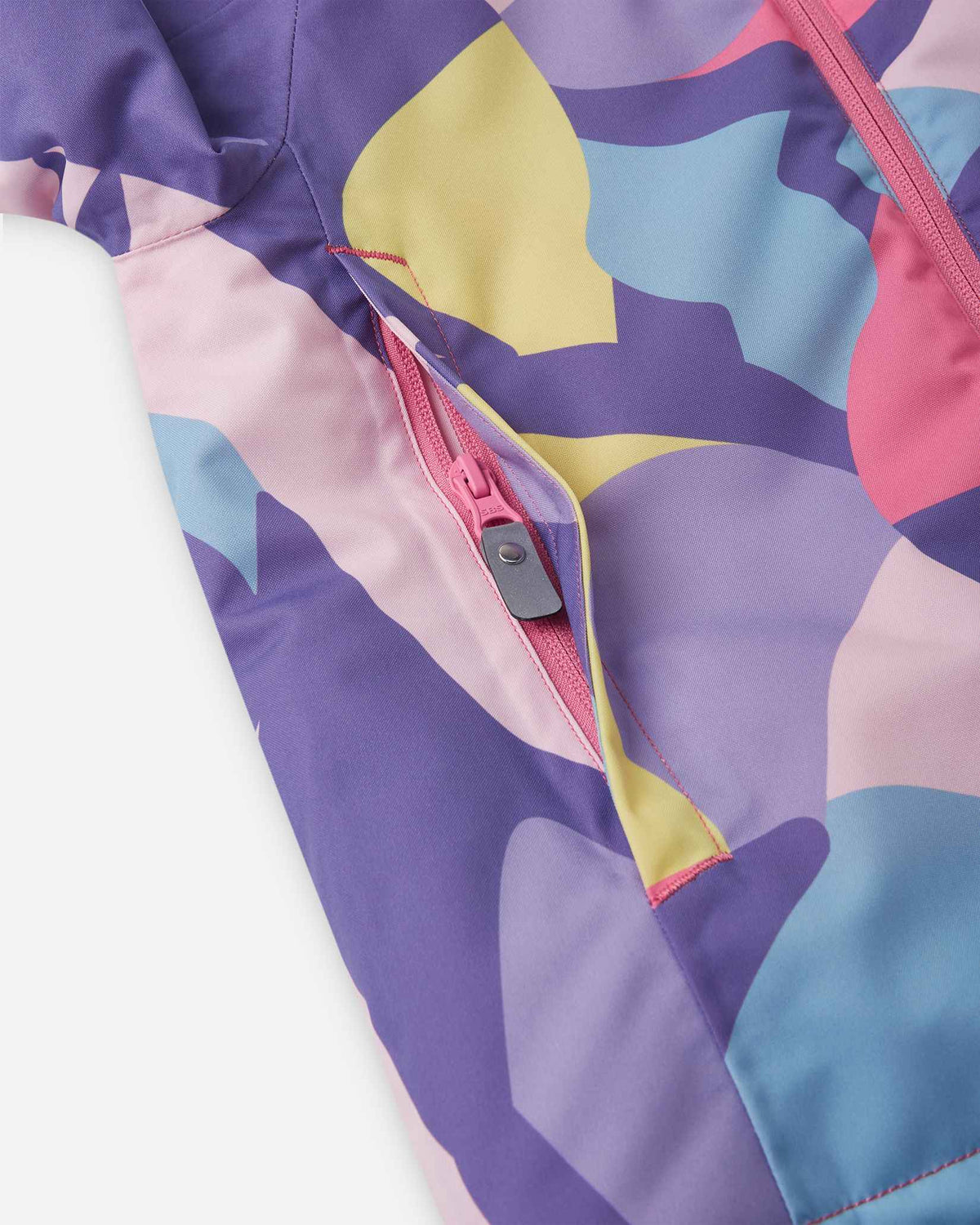 A bright pink and purple patterned pocket on the Blooming Lilac kids ski jacket.