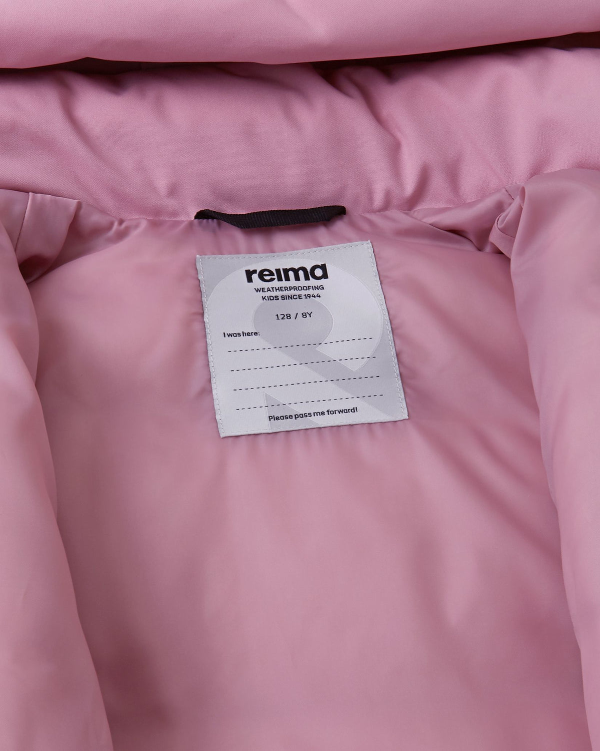 Inside collar view of the grey pink Reima Parkkala girls' winter outerwear, displaying the smooth pink lining, Reima weatherproofing certification, and a dedicated space for writing a child's name for school or camp.