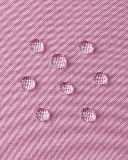Extreme macro shot of water droplets forming tight beads on the grey pink outer fabric of the Reima Parkkala long down coat, demonstrating its premium BIONIC-FINISH ECO dirt- and water-repellent surface.