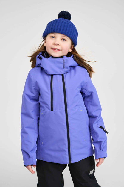Lifestyle portrait of a young girl wearing the breezy violet Reima Perille kids' ski jacket with a blue knit beanie, showcasing the relaxed fit and warm 140g Fellex recycled insulation during winter play.