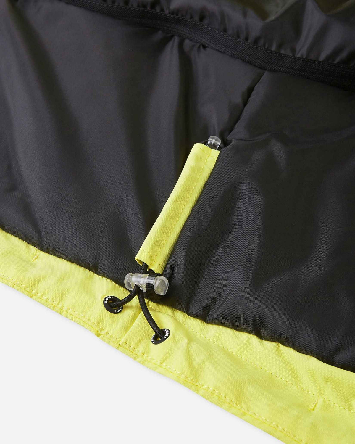 Detailed view of the interior bottom hem on the yellow Reima Perille ski jacket, featuring an elastic cinch cord with a secure toggle stop for a custom, draft-proof fit around the waist.