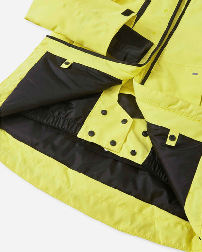 Open view of the lower interior lining on the yellow Reima Perille ski jacket, showcasing the snap-closure powder skirt and jacket-to-pants connection loops engineered to block deep snow and cold drafts.