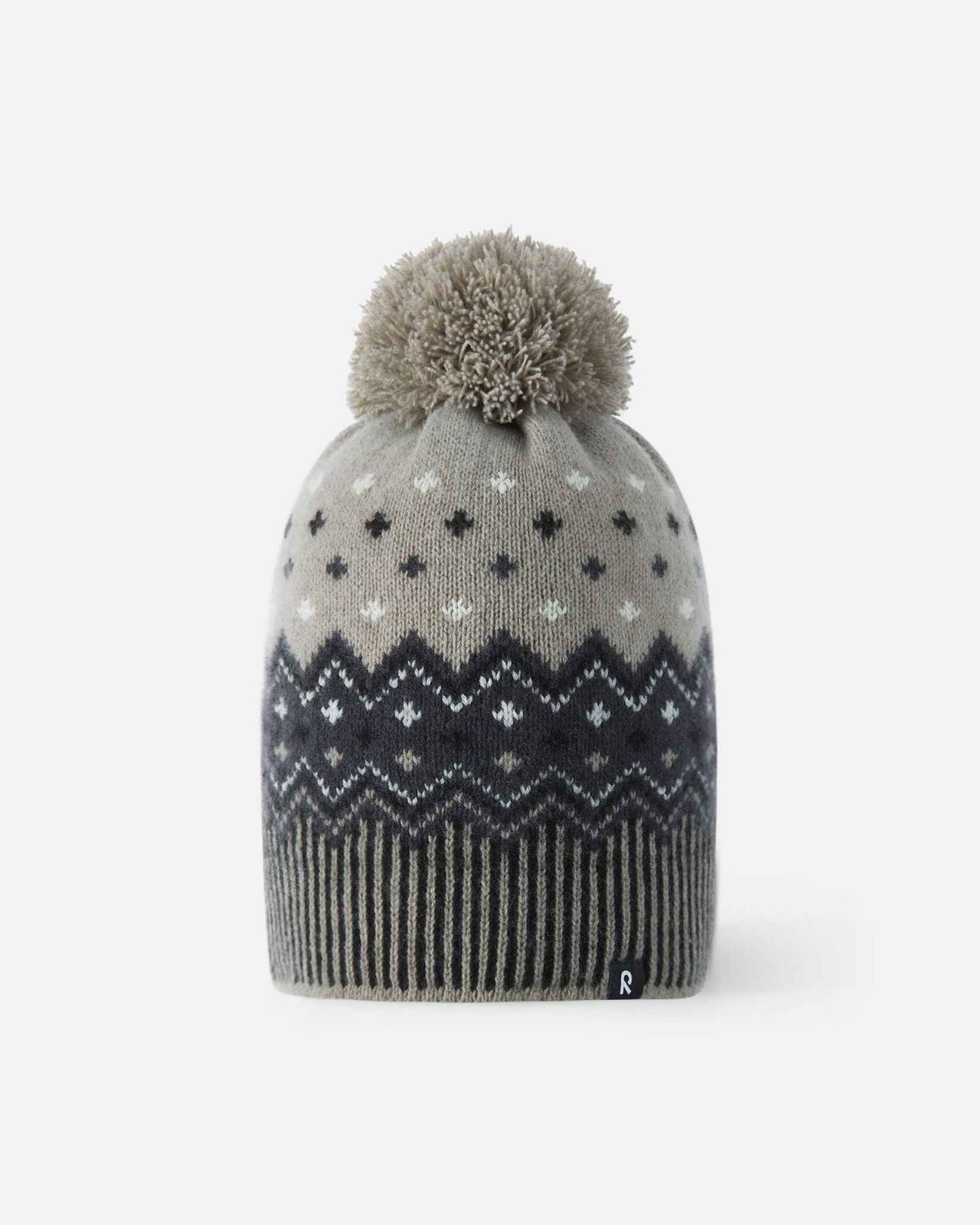 Front flat lay view of the black and charcoal Reima Pohjoinen kids' merino wool winter beanie, featuring a traditional Nordic jacquard snowflake pattern, a ribbed hem, a fluffy yarn pom-pom, and a subtle reflective logo tag.