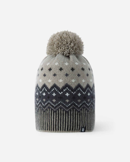 Front flat lay view of the black and charcoal Reima Pohjoinen kids' merino wool winter beanie, featuring a traditional Nordic jacquard snowflake pattern, a ribbed hem, a fluffy yarn pom-pom, and a subtle reflective logo tag.