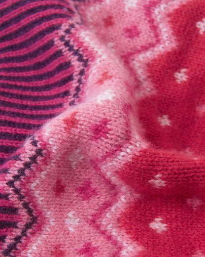 Macro close-up of the intricate jacquard knit texture on the deep purple Reima Pohjoinen kids' winter beanie, highlighting the soft, insulating merino wool yarn structure.