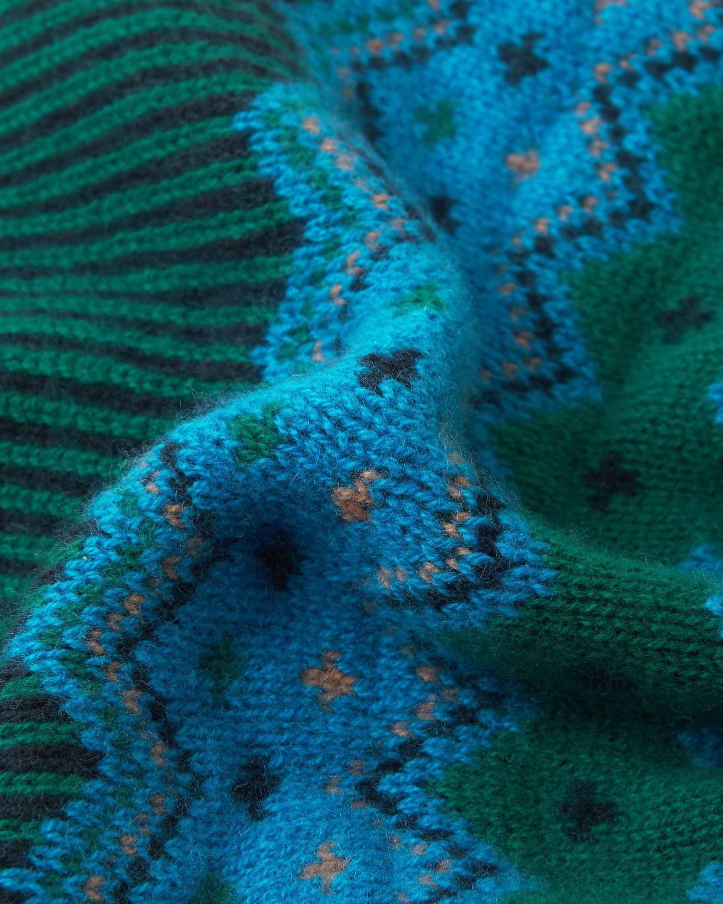 Macro close-up of the premium navy, green, and azure blue merino wool knit on the Reima Pohjoinen kids' beanie, demonstrating the soft yarn density and rich colorway.