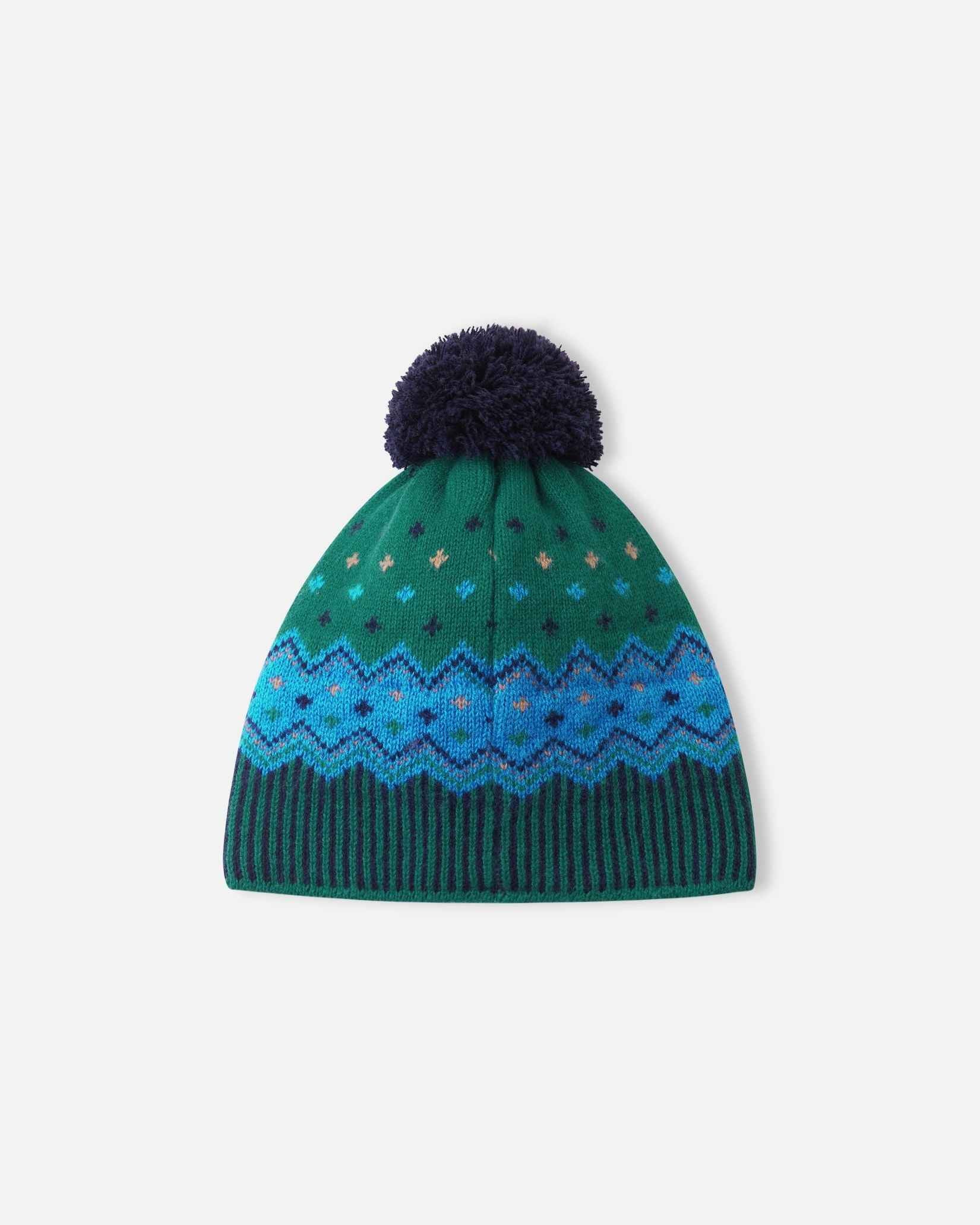 Back flat lay view of the navy and pine green Reima Pohjoinen kids' merino wool beanie, highlighting the continuous knitted Fair Isle pattern and durable pom-pom construction.