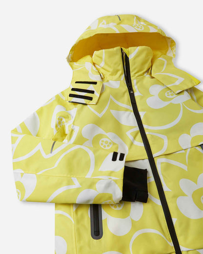 Close-up detail of the yellow Reima Posio kids' waterproof ski jacket, highlighting the durable sealed main zipper, high protective collar, and dynamic white floral design.