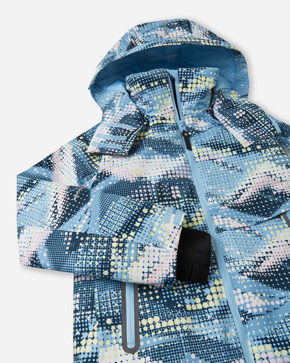 Angled front view of the frozen blue Reima Posio kids' waterproof ski jacket, showcasing the digital mountain pattern, adjustable hood, and inner lycra cuff designed for winter sports.