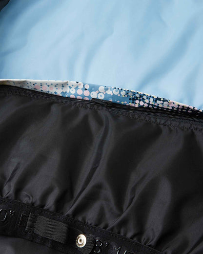 Detail view of the internal snap-button powder skirt inside the frozen blue Reima Posio kids' ski jacket, designed to keep out snow and cold drafts during winter activities.