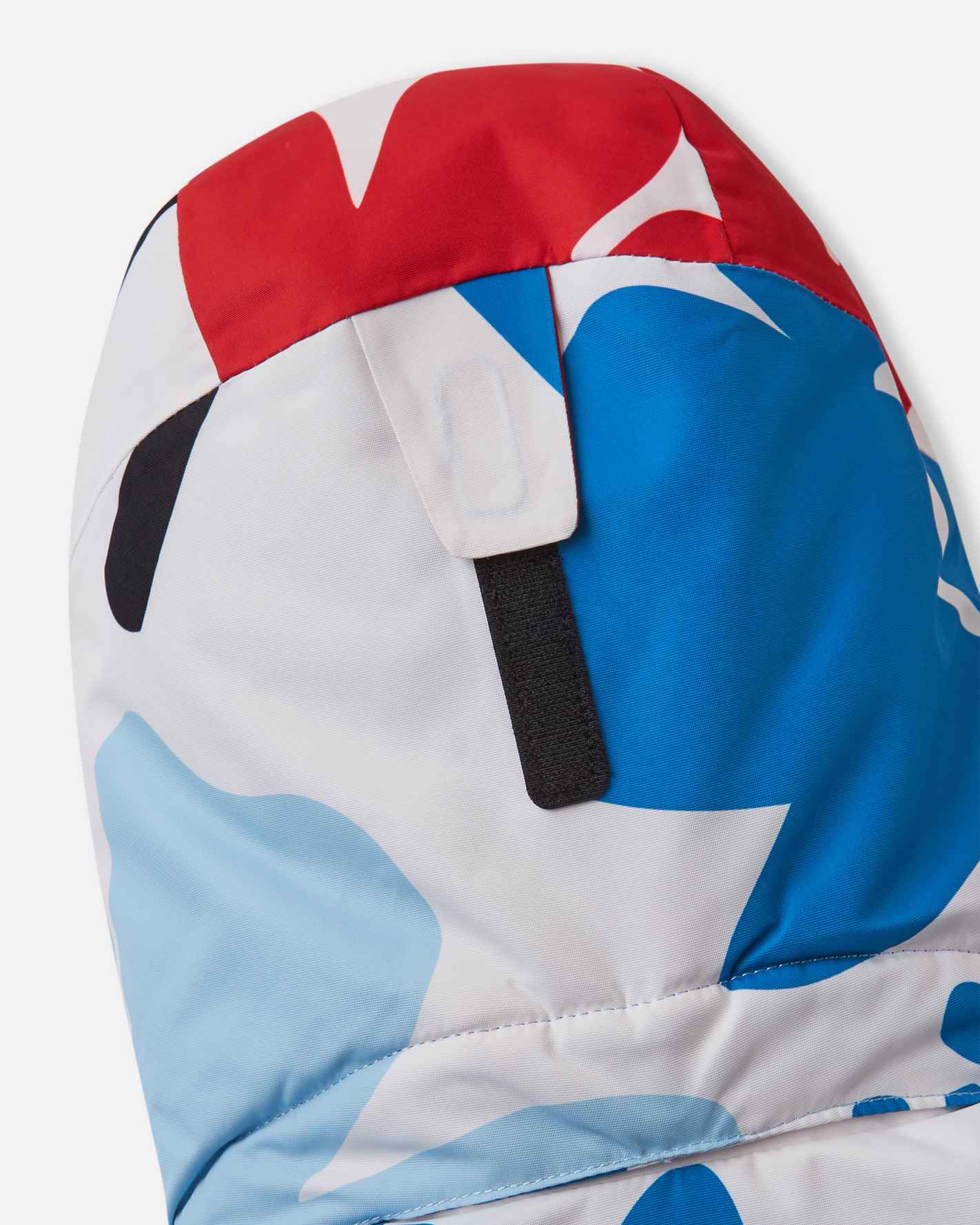 Close-up view of the rear velcro adjustment strap on the helmet-compatible hood of the white Reima Posio kids' waterproof ski jacket.