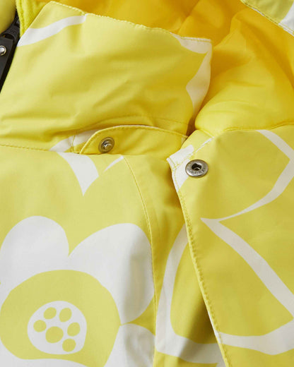 Close-up detail of the protective chin guard and secure collar snap buttons on the yellow Reima Posio kids' waterproof ski jacket, highlighting the durable hardware and bright white floral print.