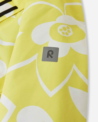 Close-up of the safety-enhancing reflective Reima logo patch on the sleeve of the yellow Posio kids' waterproof ski jacket, providing visibility in low-light winter conditions.