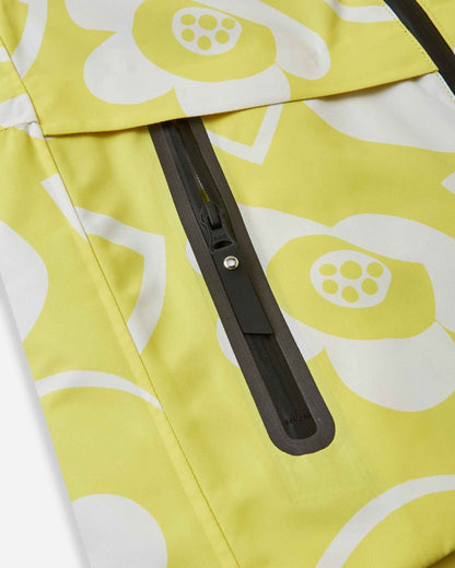 Close-up of the sealed, water-resistant zipper pocket on the front panel of the yellow Reima Posio kids' winter ski jacket, showcasing the durable construction designed for snow sports.