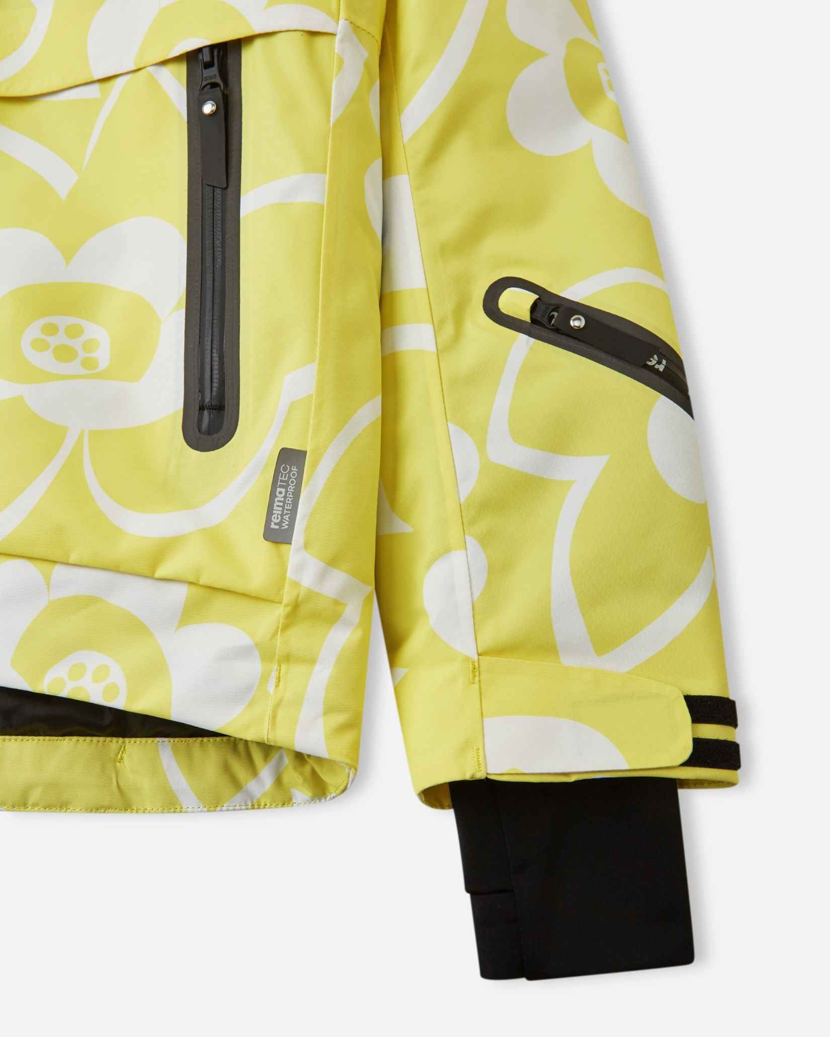 Detail view of the waterproof zippered sleeve ski pass pocket, velcro cuff adjuster, and inner lycra cuff with thumbhole on the yellow Reima Posio kids' ski jacket.