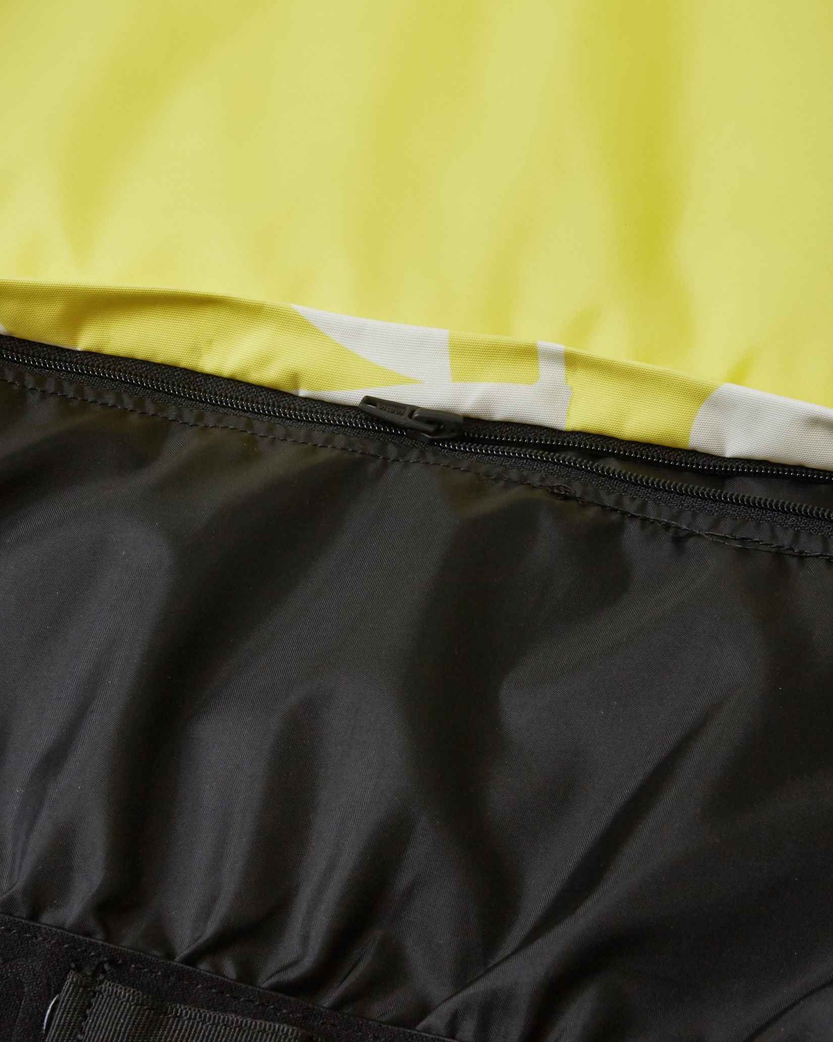 Detailed view of the internal elastic snow powder skirt with secure snap buttons inside the yellow Reima Posio kids' waterproof ski jacket, designed to keep out snow and cold drafts.