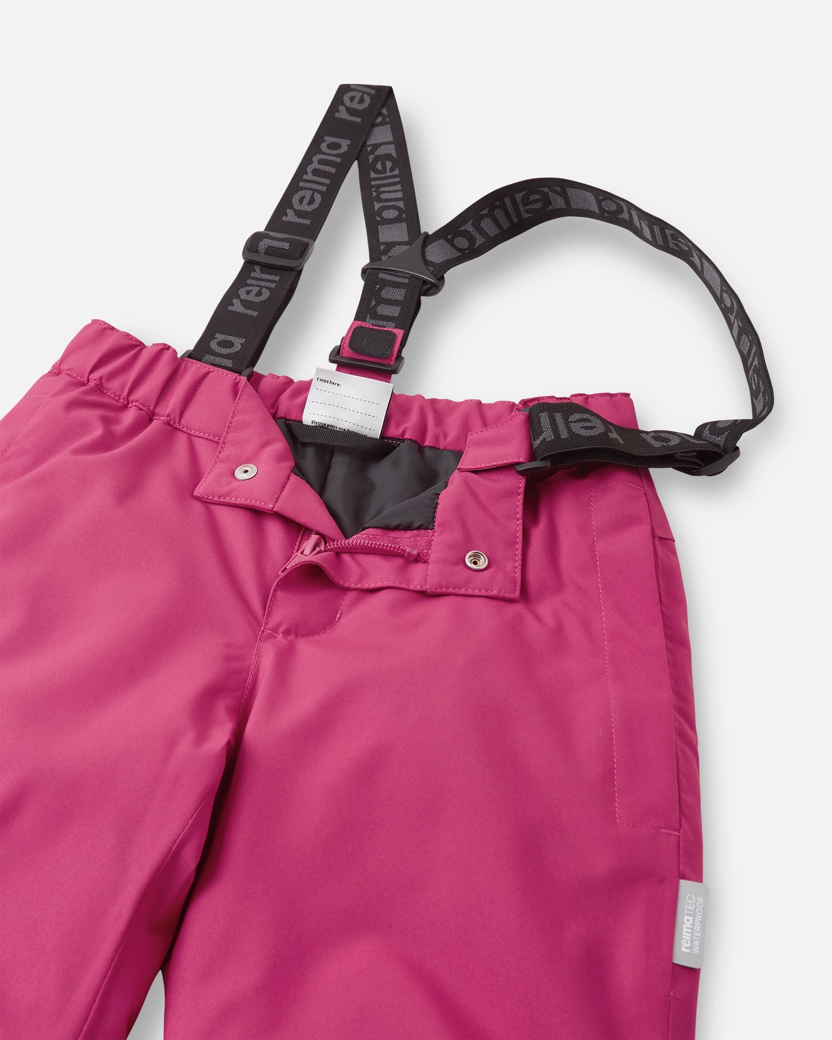 Close-up detail of the front waist on the rosy berry Reima Proxima kids' ski pants, showing the secure snap buttons, smooth zipper fly, elastic back waistband, and adjustable branded suspenders.