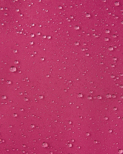 Macro close-up of water droplets actively beading and rolling off the rosy berry outer shell of the Reima Proxima kids' ski pants, visually highlighting the high-performance breathable and waterproof Reimatec technology.