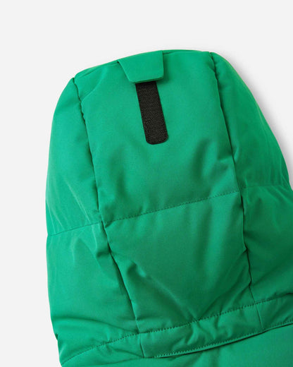 Close-up of the back of the insulated hood on the green Reima Ranua kids' down ski jacket, detailing the velcro adjustment tab used to customize the fit for maximum warmth and visibility.