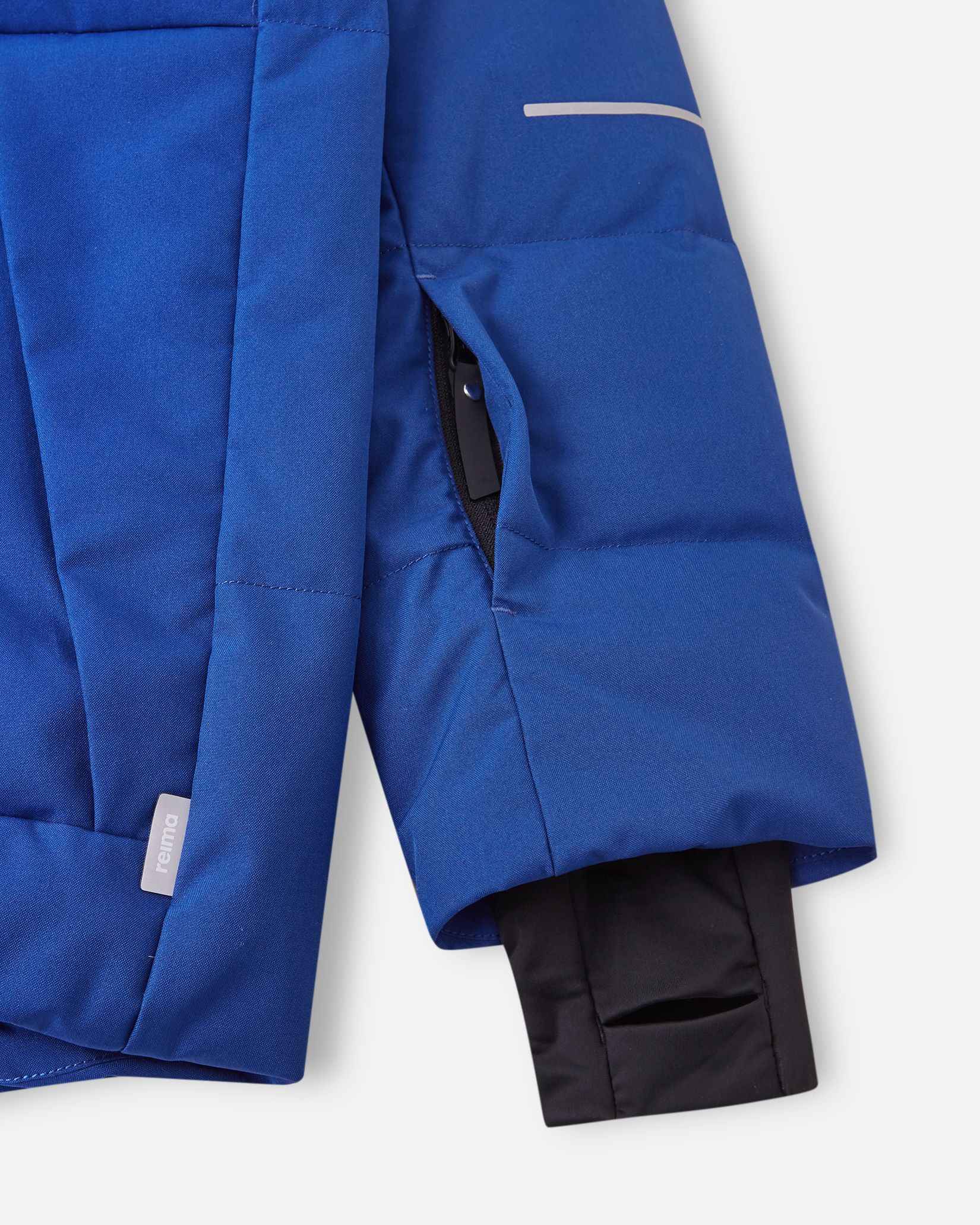 Close-up of the left sleeve on the Reima Ranua kids' down ski jacket in twilight blue, showing the hidden zippered ski pass pocket, reflective safety detailing, and the comfortable inner lycra thumbhole sleeve designed to seal out cold and snow.