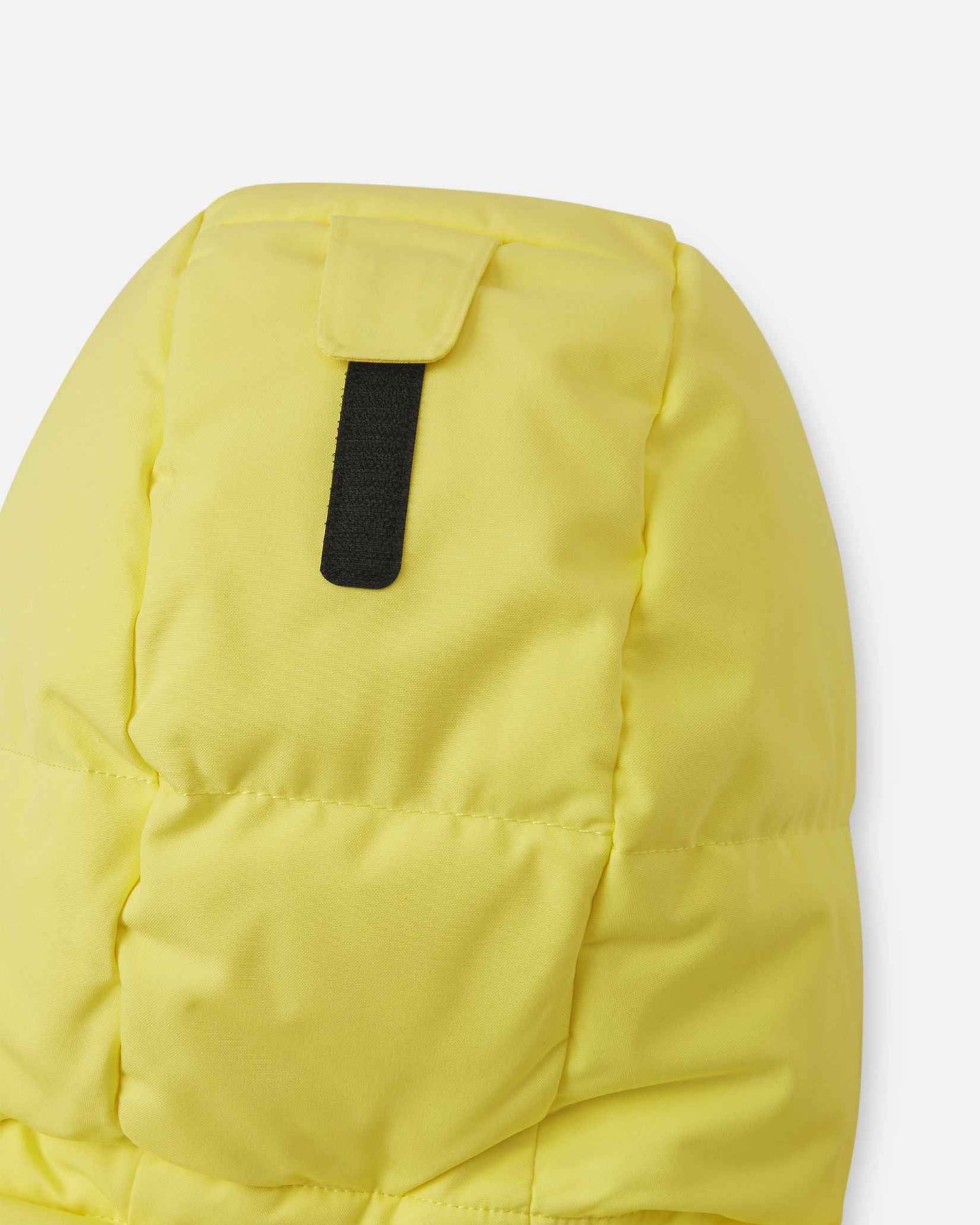 Close-up of the back of the insulated hood on the yellow Reima Ranua kids' down ski jacket, detailing the velcro adjustment tab used to customize the fit for maximum warmth and visibility.
