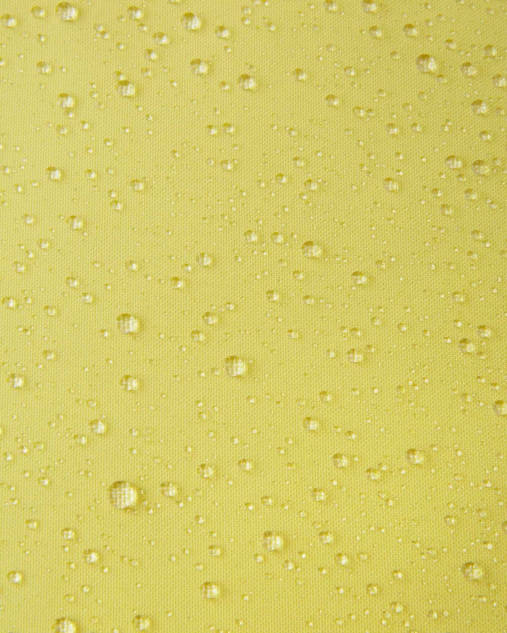 A detailed close-up texture shot of water droplets beading up cleanly on the bright yellow water-repellent fabric of a Reima Ranua kids' down ski jacket, demonstrating its durable weather-resistant performance for outdoor winter play.