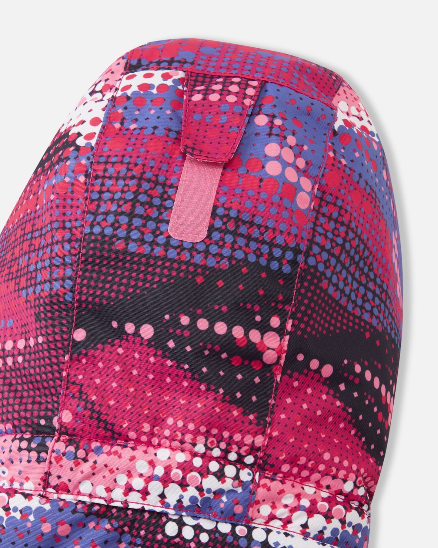 Detail shot of the back of the hood on the rosy berry Reima Reach girls' ski suit, highlighting the adjustable velcro tab that allows parents to easily customize the hood depth for a secure, windproof fit over a ski helmet or winter beanie.